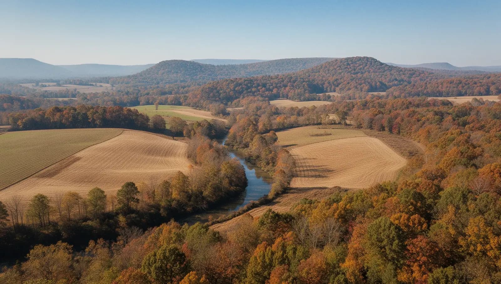 Aerial view of rolling hayfields and autumn hardwoods in north Alabama
