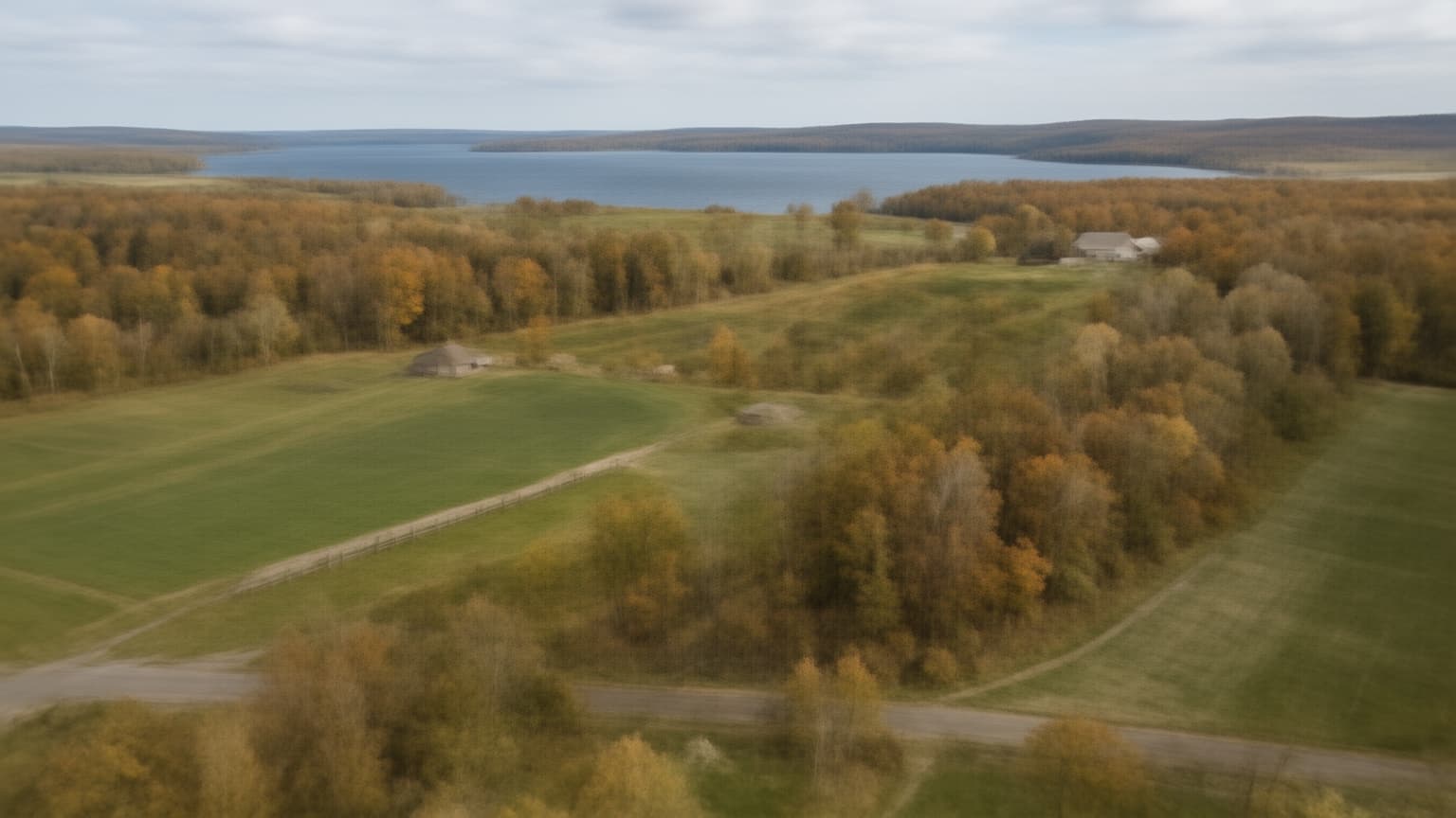 Aerial view of Wisconsin dairy farmland and hardwood forest with lake in the distance